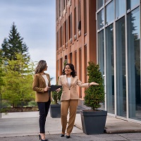 A property manager speaking with a client outside of a building.